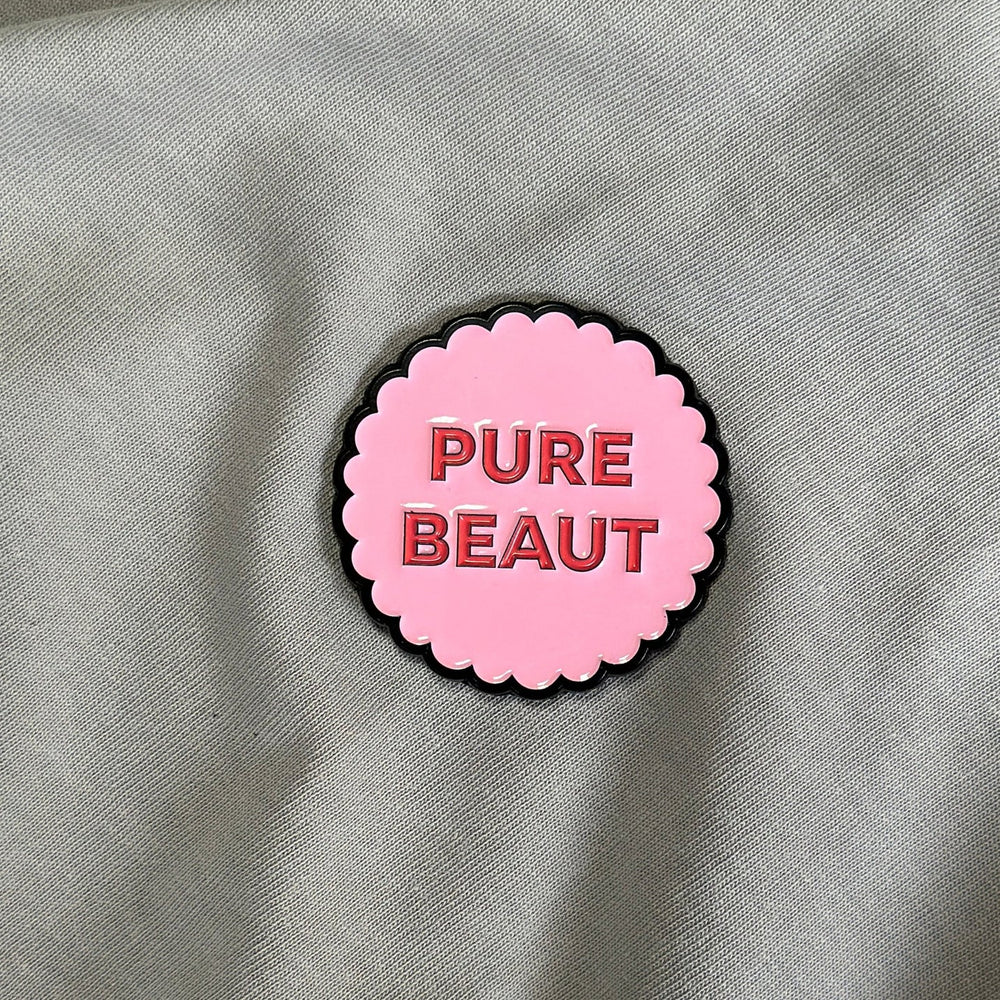 Pink magnet with 'PURE BEAUT' text.